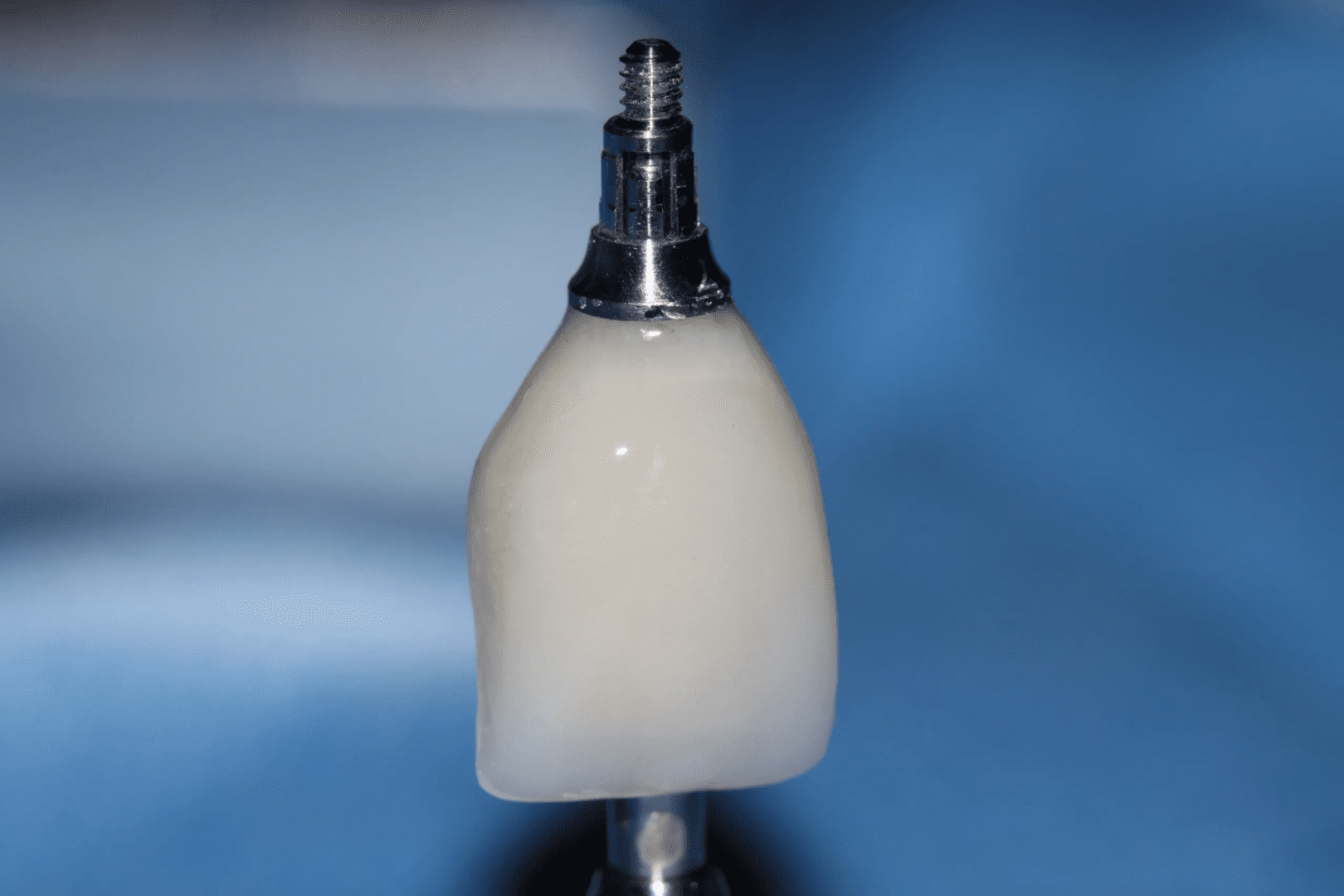 A white bottle sitting on top of a metal stand.